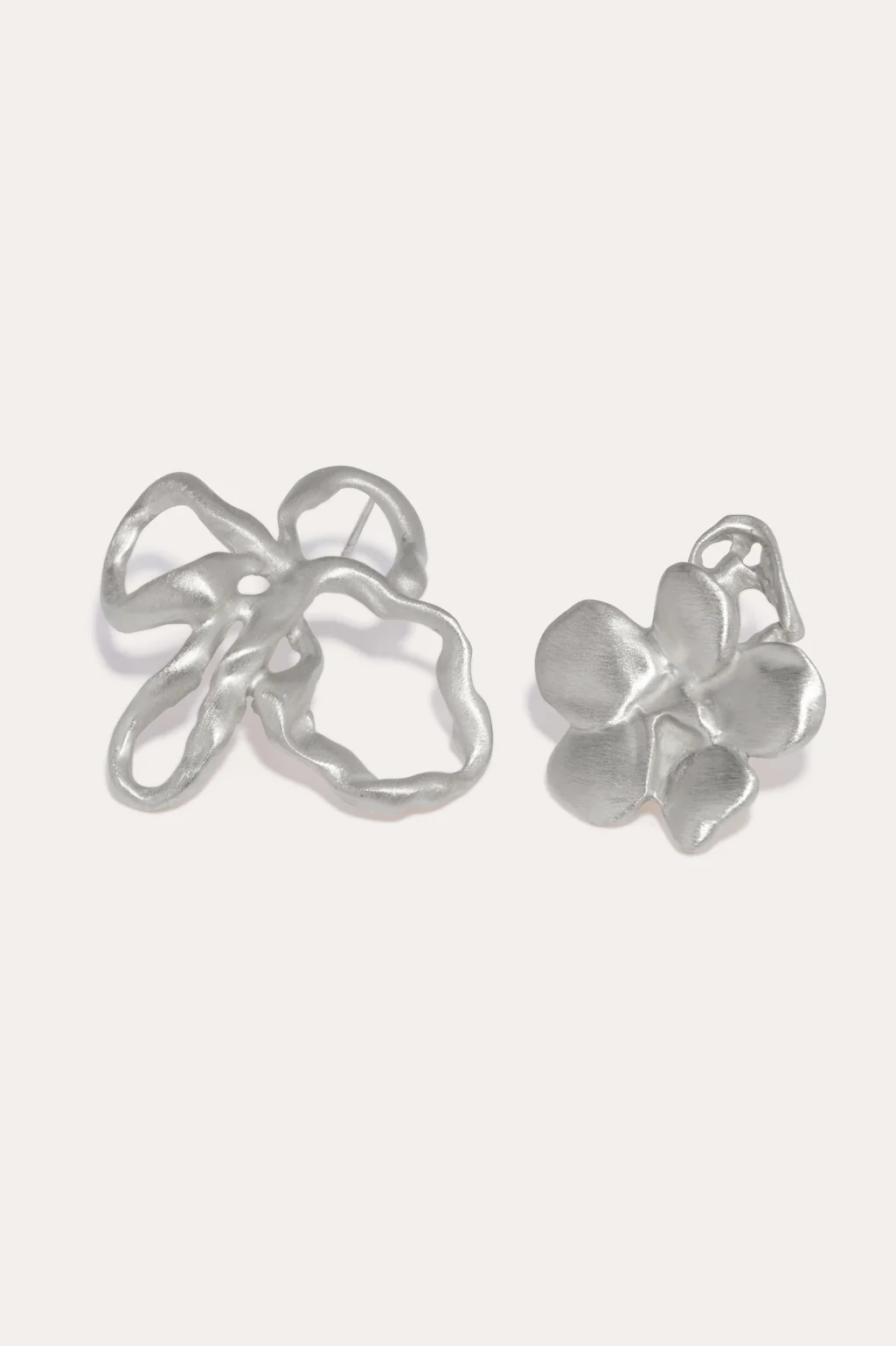 Completedworks mismatched earrings with sculptural flower shapes, adding a modern touch.