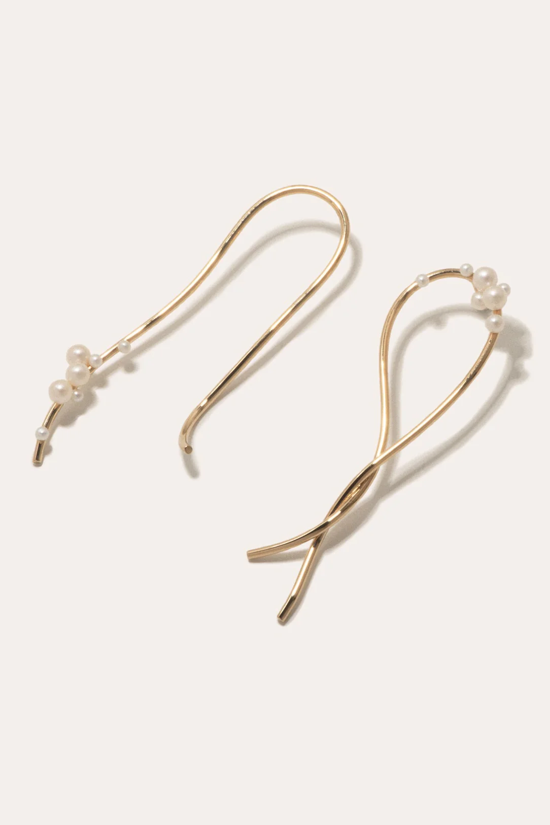 Long freshwater pearl earrings gracefully reaching toward the collarbone, crafted by Completedworks.