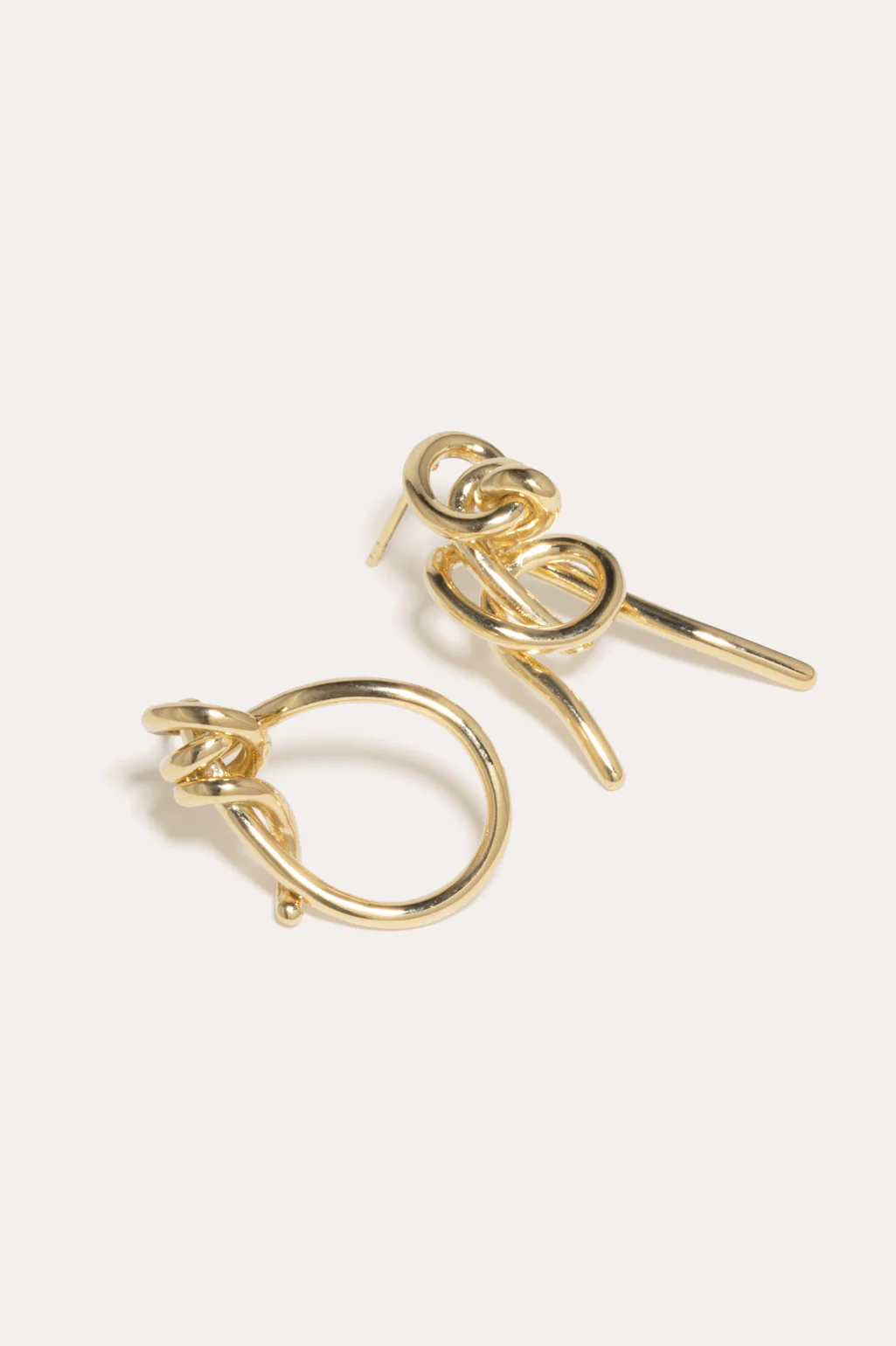 Gold vermeil earrings featuring mismatched knots, adding a modern, artistic touch by Completedworks.