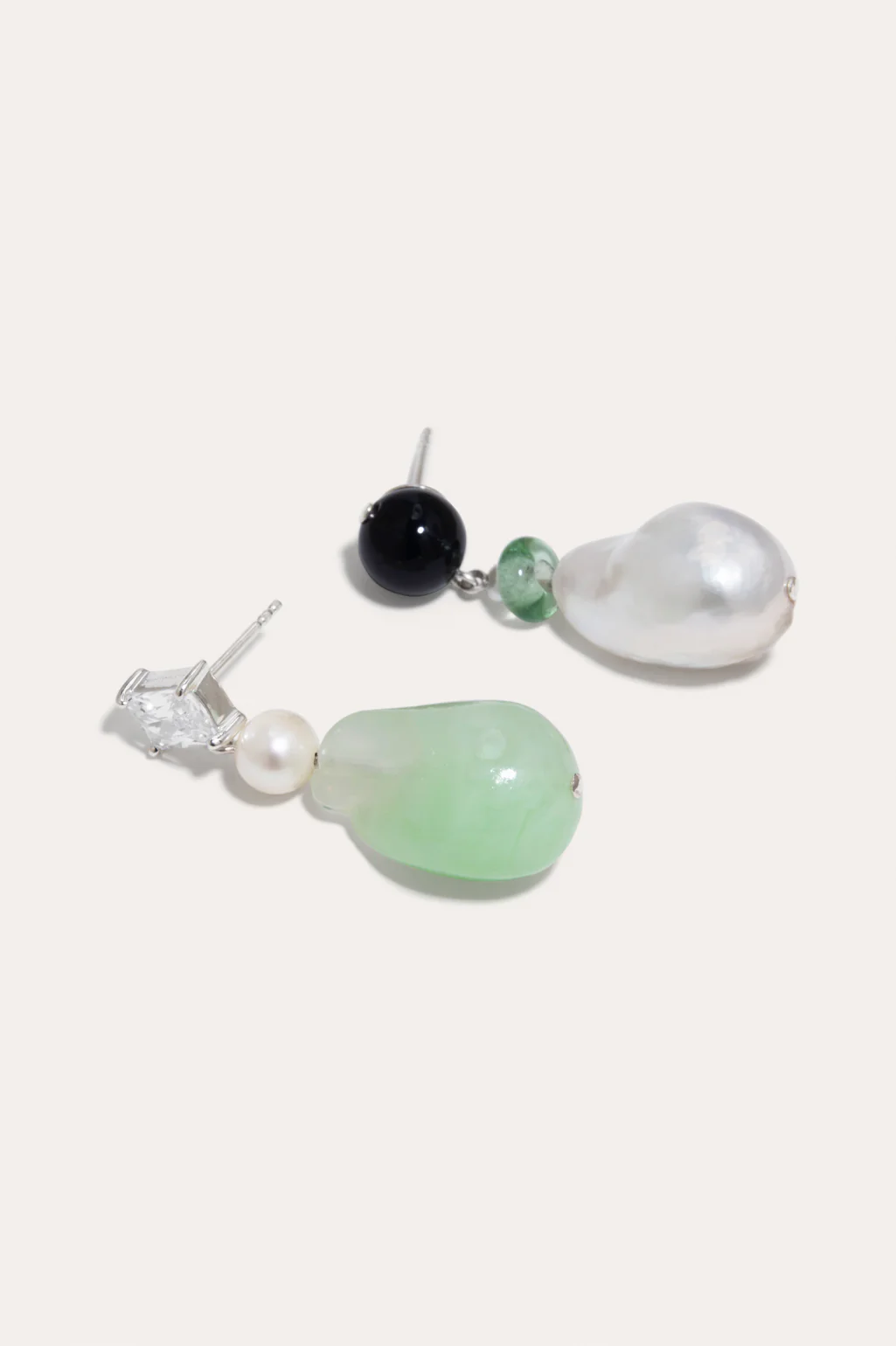 Sustainable earrings by Completedworks, combining baroque pearls, onyx, and freshwater pearls in a recycled silver setting.
