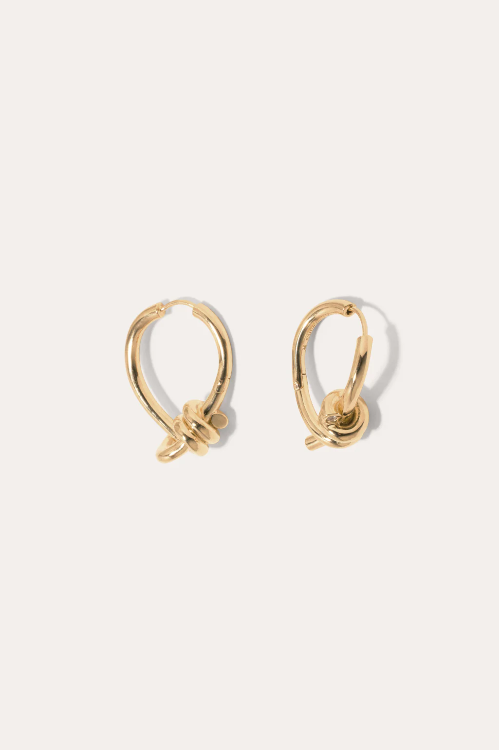 Completedworks gold-plated hoop earrings featuring a twisted, organic shape for a modern and artistic look.
