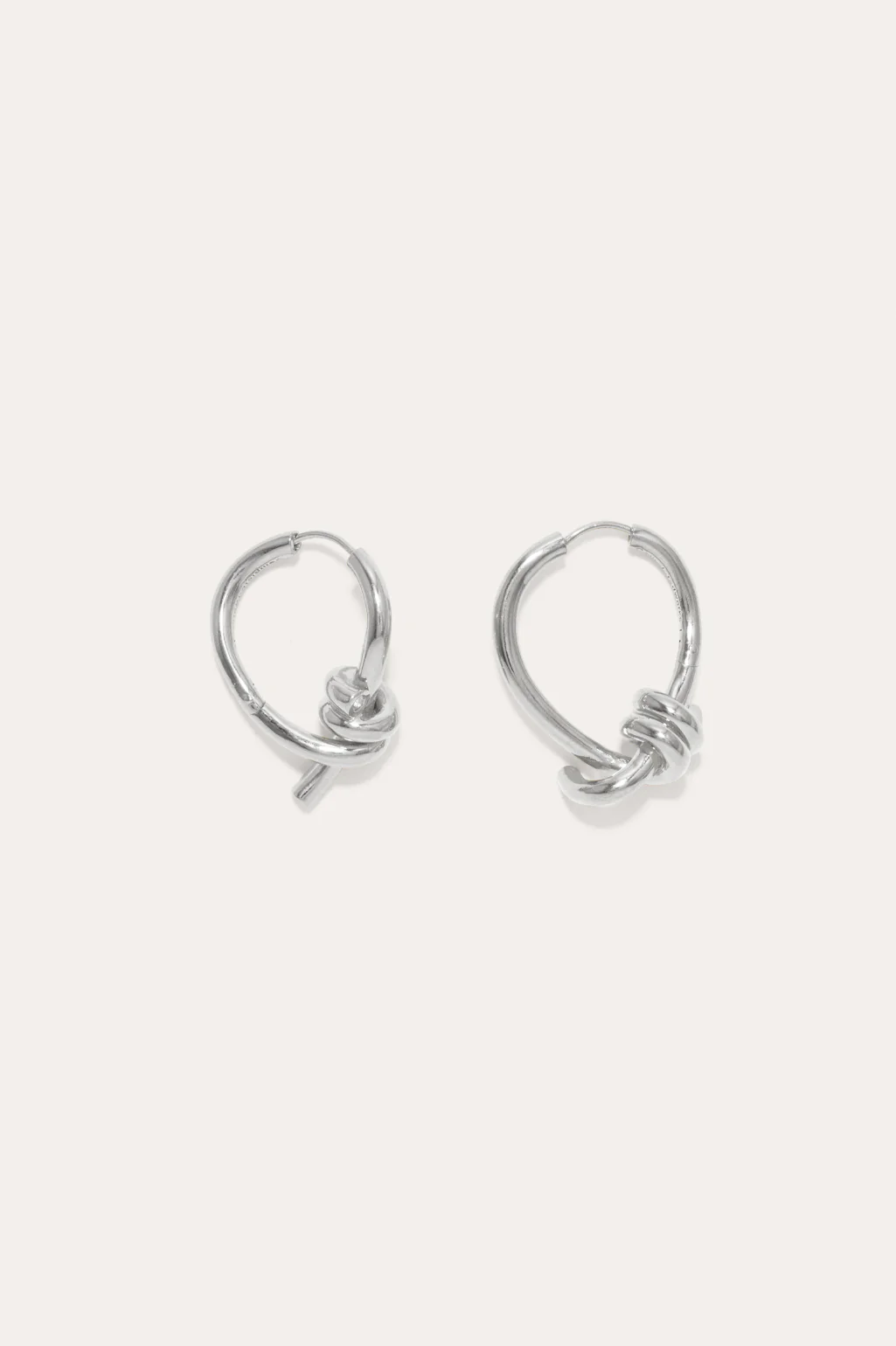 Completedworks sculptural silver hoop earrings with a unique twisted design, blending minimalism and sophistication.