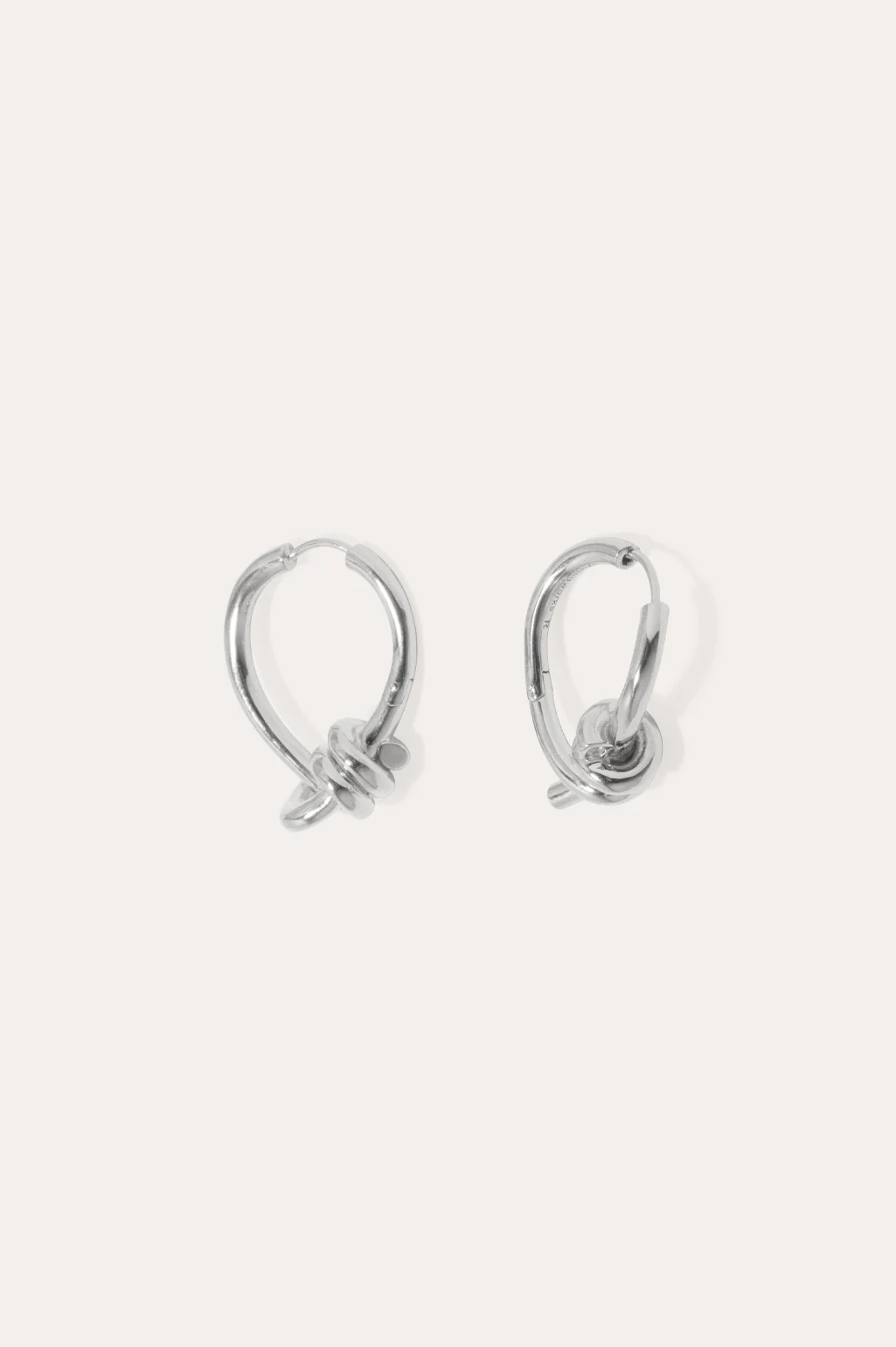 Completedworks silver hoop earrings featuring a twisted, organic shape for a modern and artistic look.