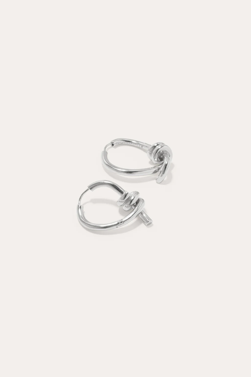 Sleek and contemporary twisting hoop earrings in sterling silver by Completedworks, perfect for everyday elegance.
