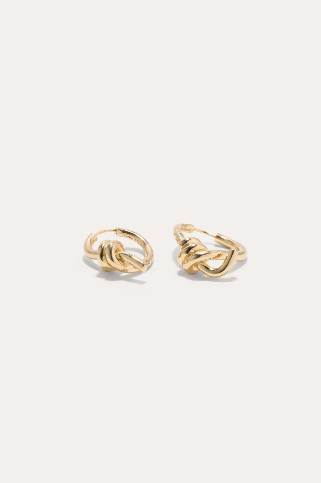 Twisting gold vermeil hoop earrings by Completedworks, crafted in gold-plated silver with an elegant sculptural design.