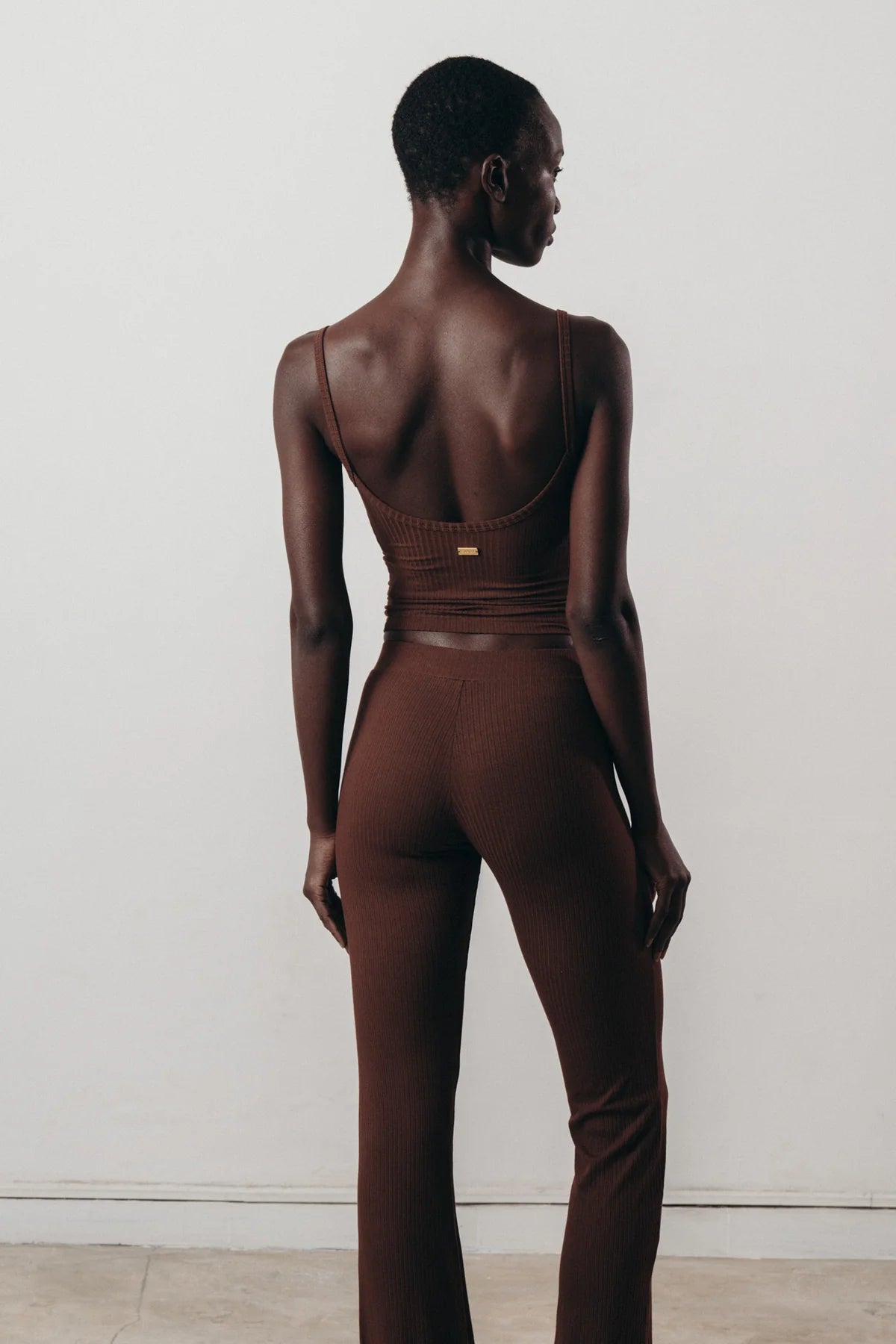 Woman wearing brown ribbed flare pants made from sustainable Ecovero™ viscose.