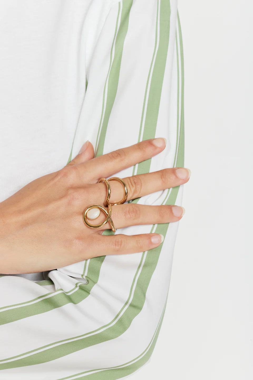 Sculptural gold two-finger ring with linked bands and oval white stone detail