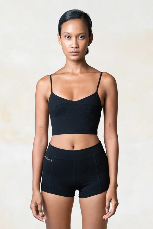 Woman wearing black yoga top made from sustainable organic bamboo.