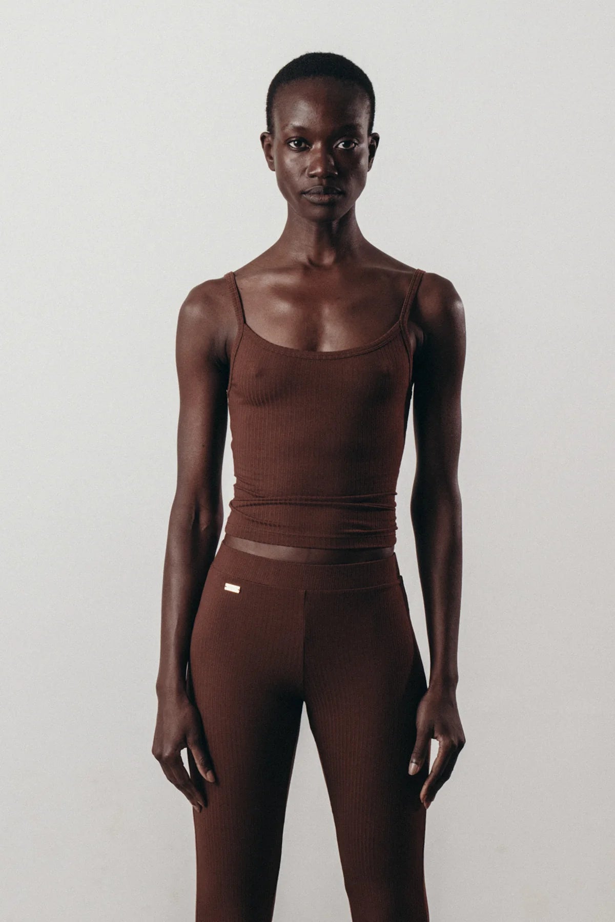 Sustainable brown ribbed top in Ecovero™ viscose worn as minimalist activewear.